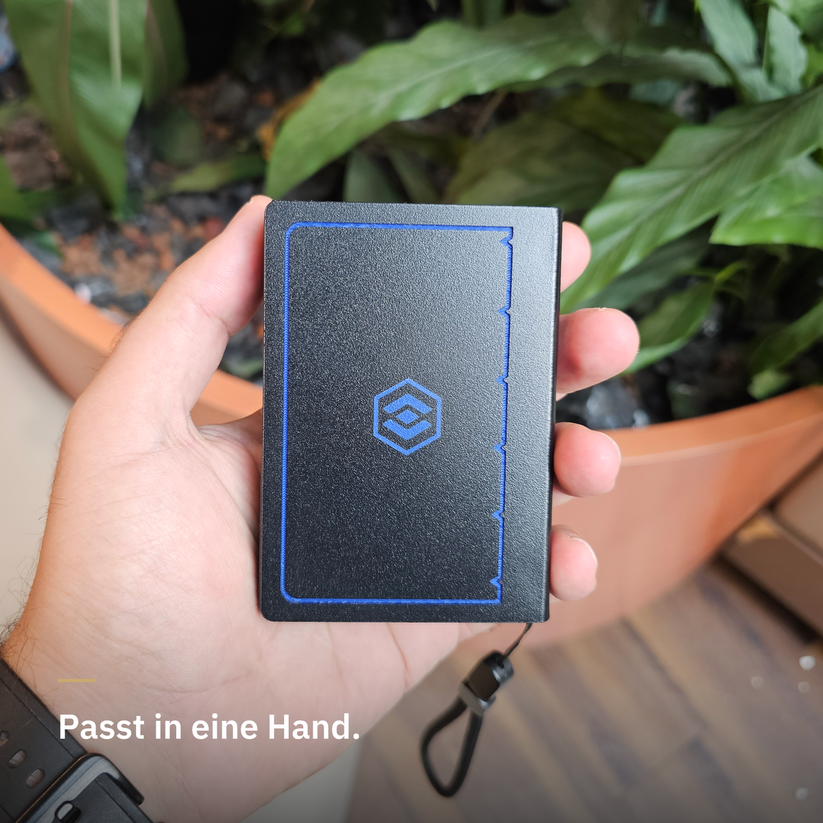 Delf WalletCase in Blau in einer Hand — Rückseite mit Logo